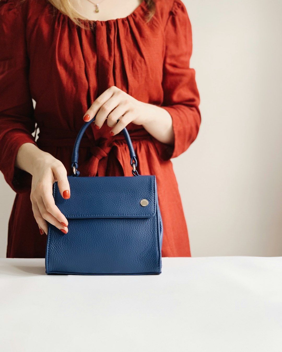 Woman with blue vegan leather handbag — sustainable fashion bag choice for 2026